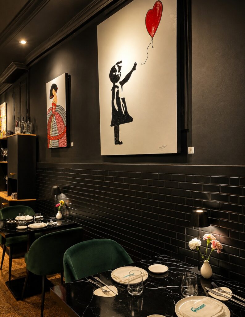 Interior de Gianna Ristorante en Chamberí, Madrid, con mesas y obras de arte